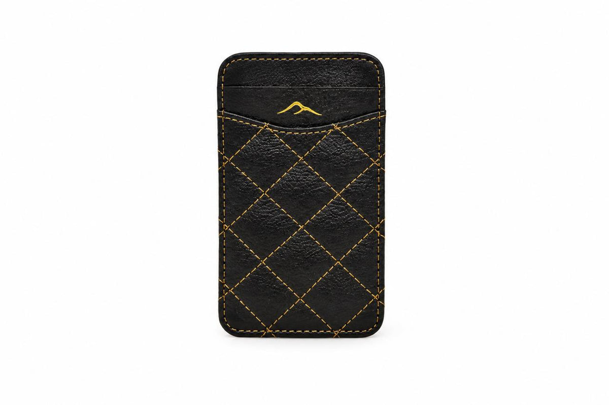 Studio photo of the black camel leather RFID card holder with gold stitching, closed, on a white background